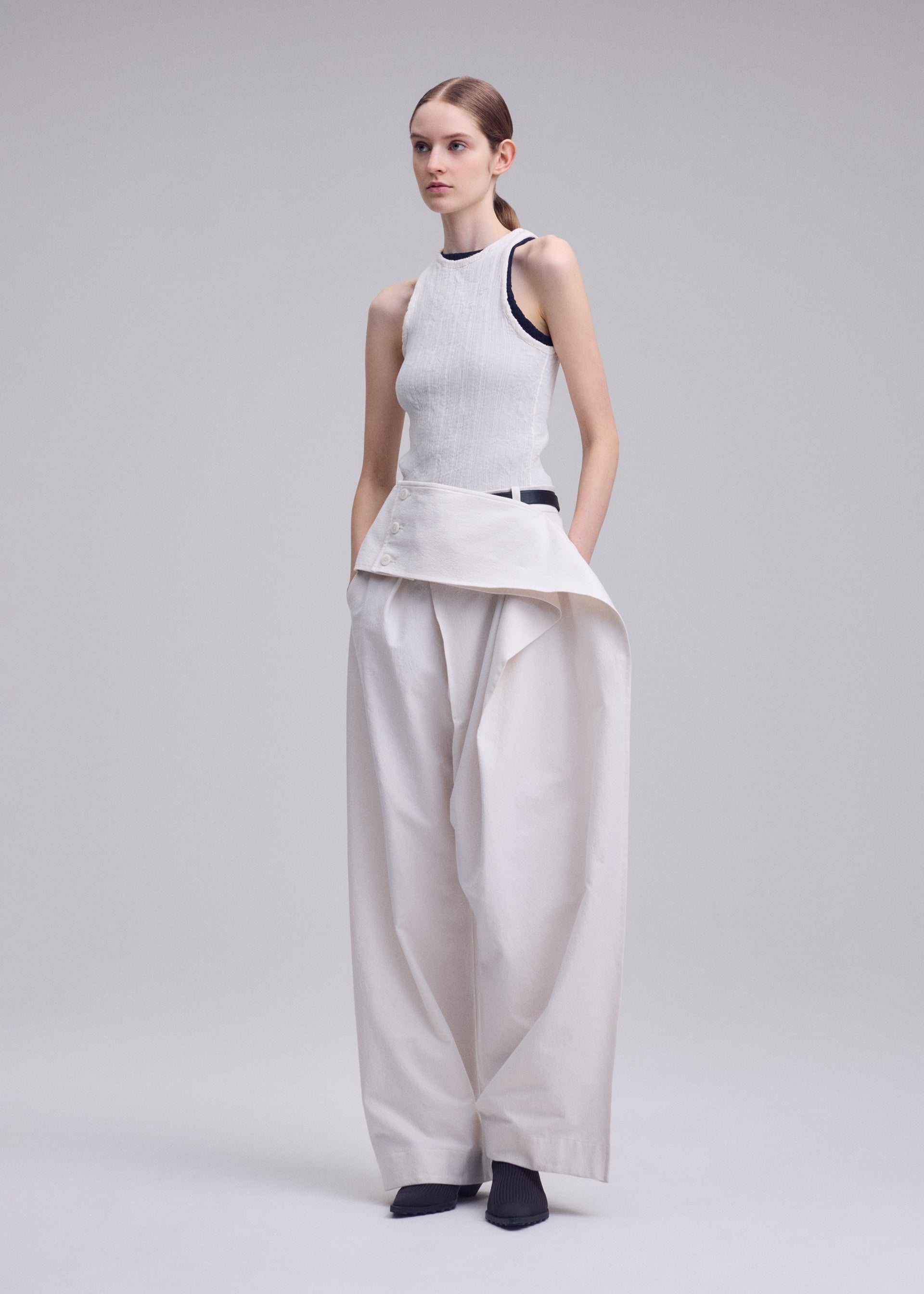 A model wears the ISSEY MIYAKE GRAINY PANTS grainy-trousers-trousers-black-3.