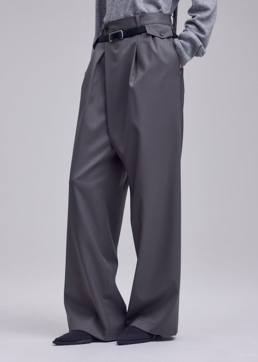 A model wears the ISSEY MIYAKE LUSTROUS WOOL PANTS trousers.