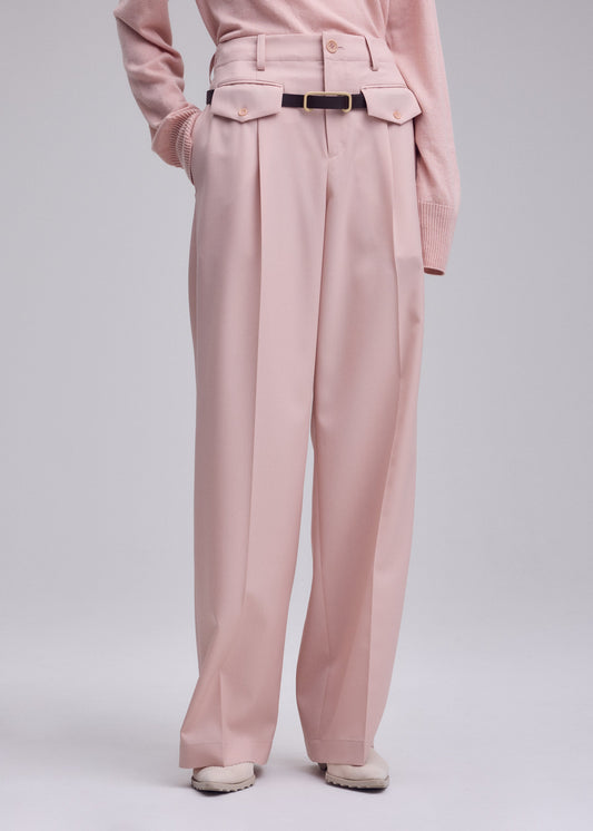 A model wears the ISSEY MIYAKE LUSTROUS WOOL PANTS trousers.