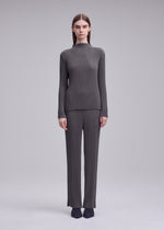 A model wears the ISSEY MIYAKE HATCHING PLEATS trousers.