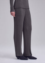 A model wears the ISSEY MIYAKE HATCHING PLEATS trousers.