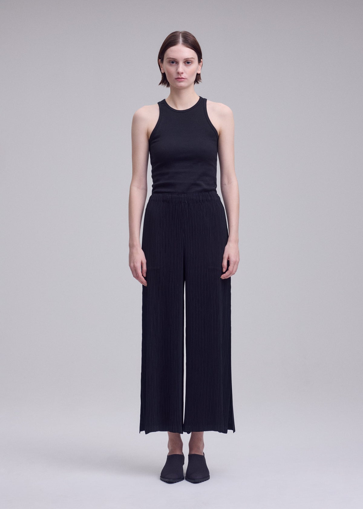 A model wears the ISSEY MIYAKE HATCHING BOTTOMS hatching-bottoms-trousers-dark-navy-1.
