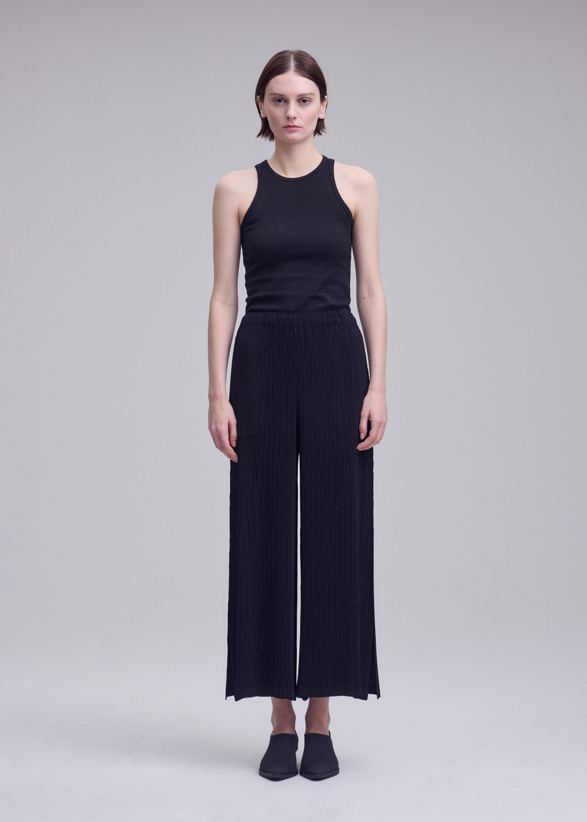 A model wears the ISSEY MIYAKE HATCHING BOTTOMS hatching-bottoms-trousers-dark-navy-1.