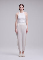 A model wears the ISSEY MIYAKE LEAF PLEATS leaf-pleats-trousers-dark-navy.