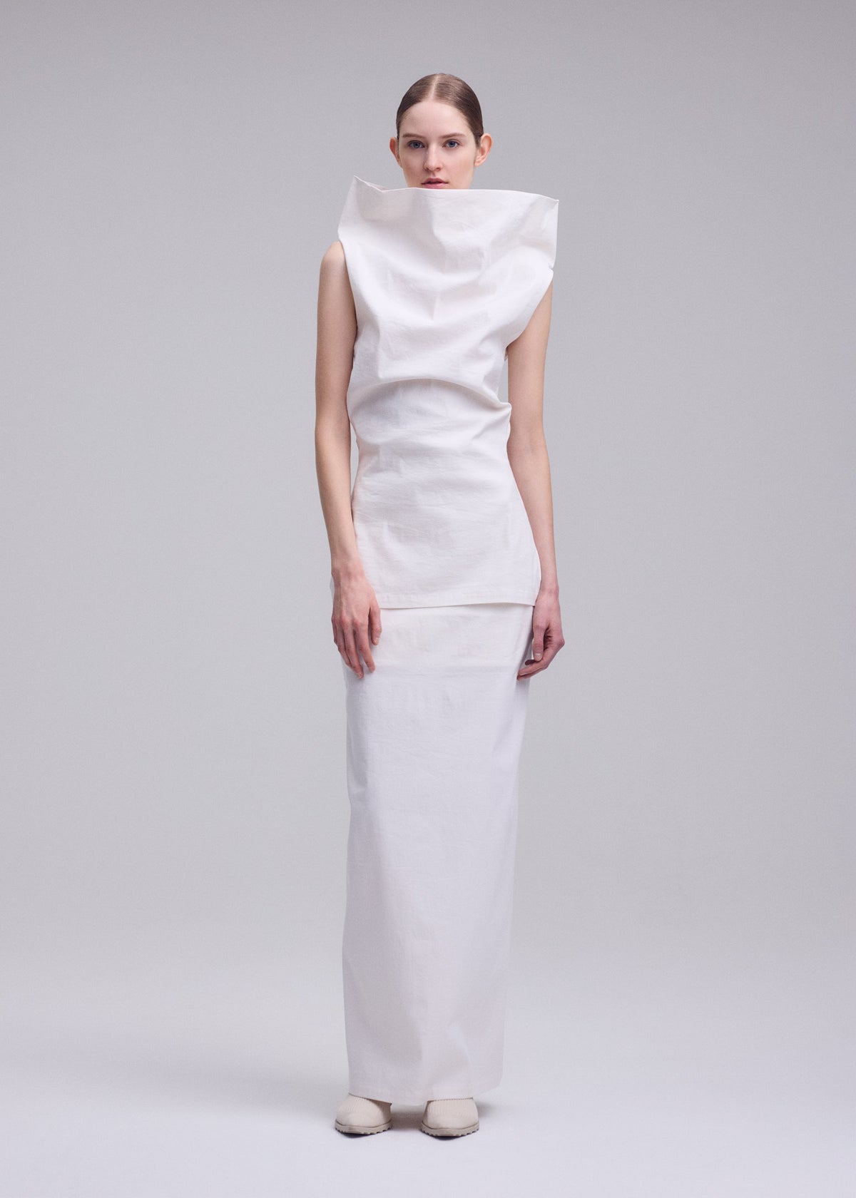 A model wears the ISSEY MIYAKE ALLOW allow-skirt-off-white.