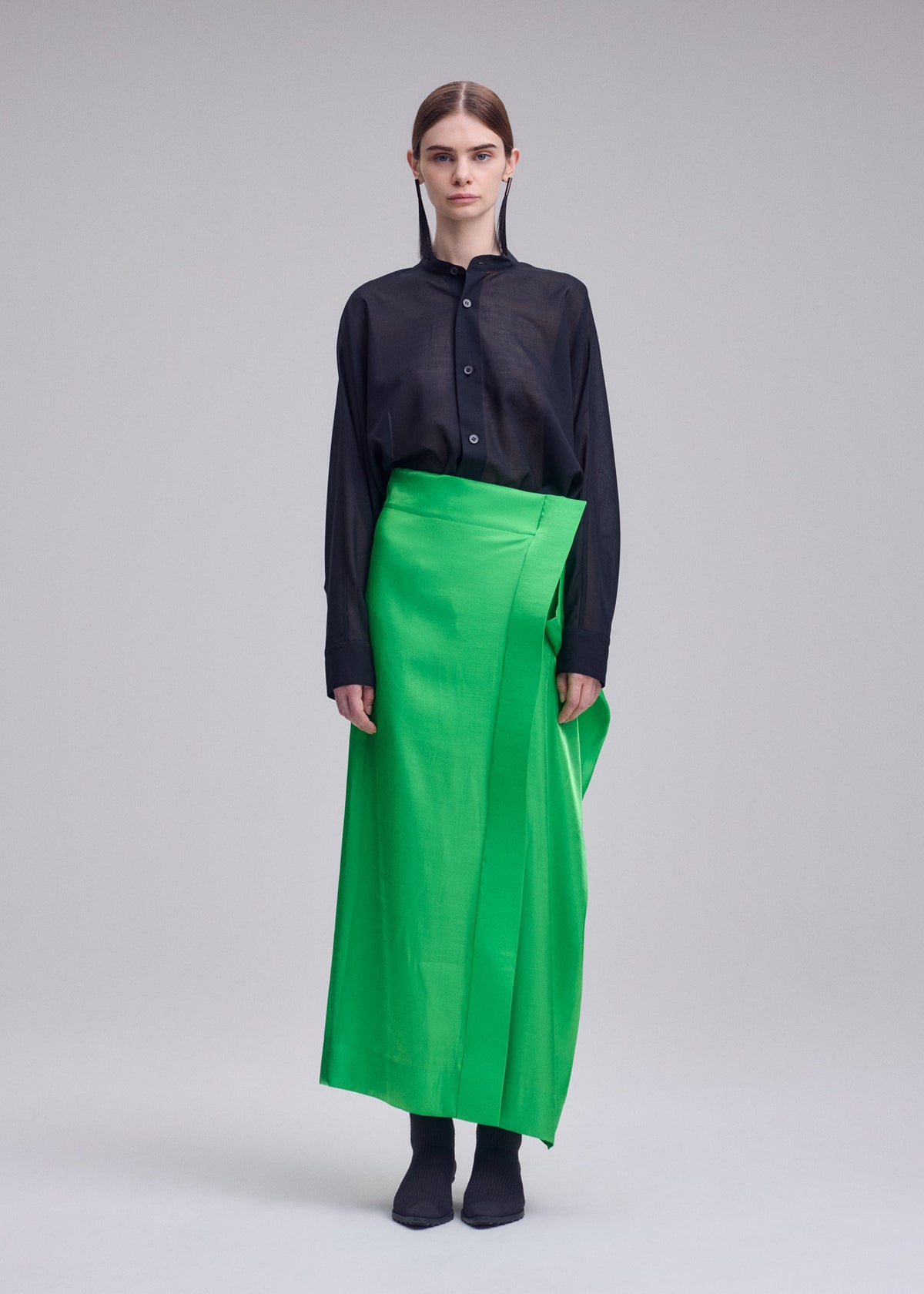 A model wears the ISSEY MIYAKE MERCURY mercury-skirt-light-grey.