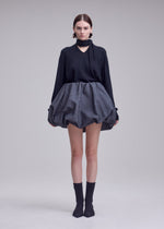 A model wears the ISSEY MIYAKE REFLECTION skirt.