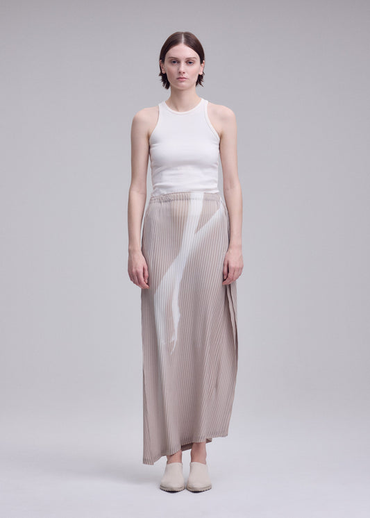 A model wears the ISSEY MIYAKE HANDS OF LOVER PLEATS skirt.