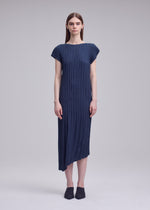 A model wears the ISSEY MIYAKE UNFURLING PLEATS unfurling-pleats-dress-off-white.