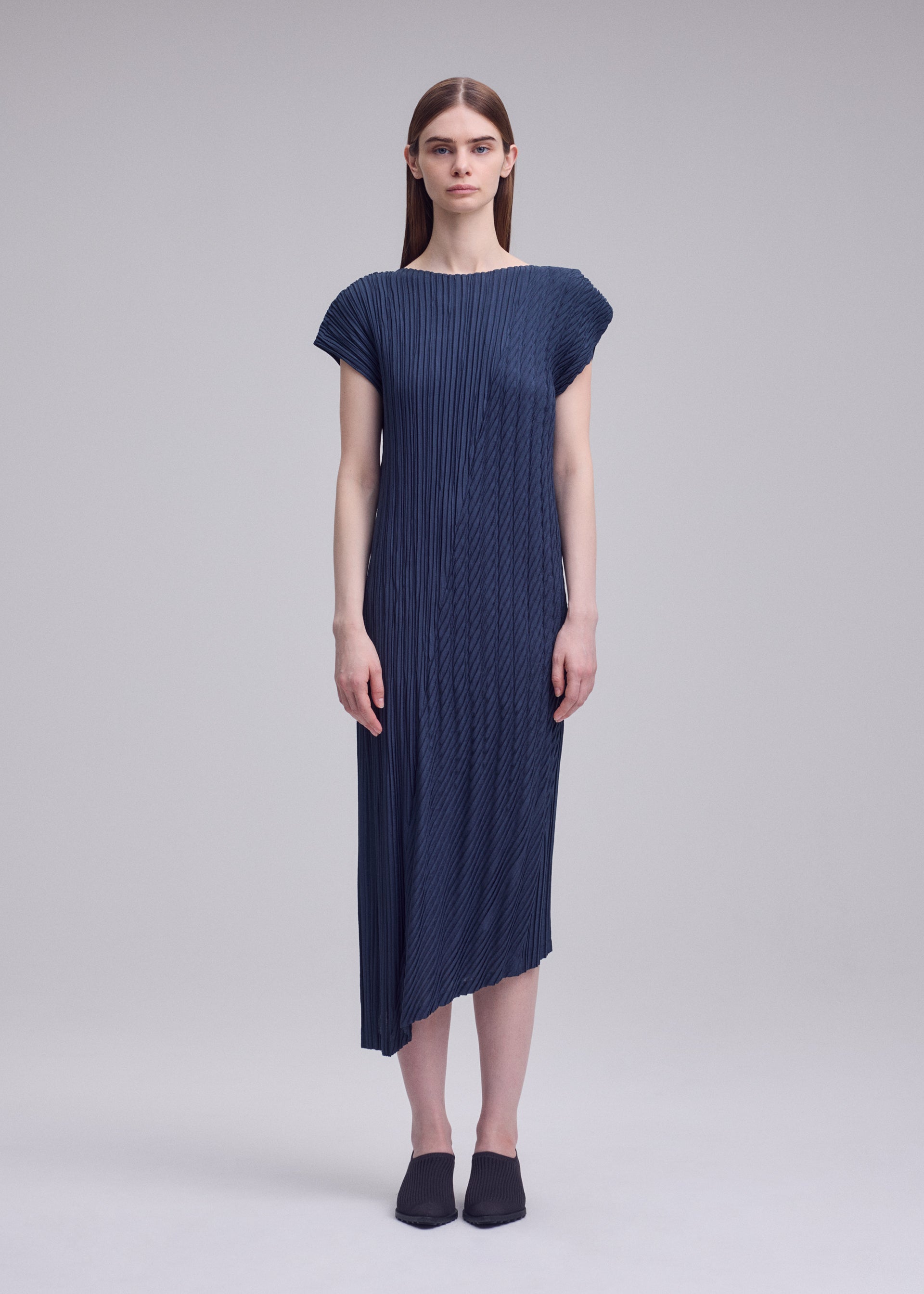 A model wears the ISSEY MIYAKE UNFURLING PLEATS unfurling-pleats-dress-off-white.