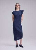 A model wears the ISSEY MIYAKE UNFURLING PLEATS unfurling-pleats-dress-off-white.