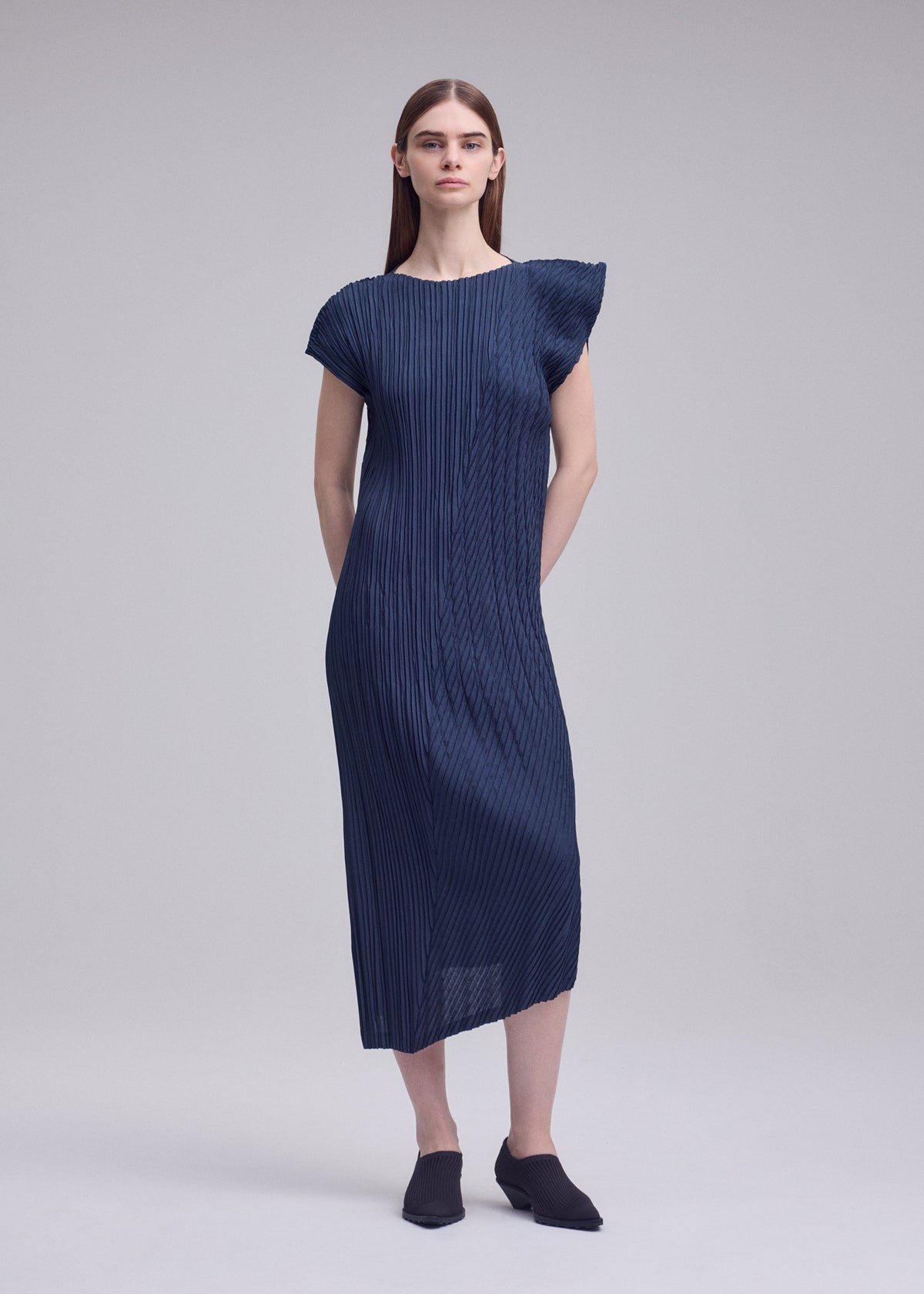 A model wears the ISSEY MIYAKE UNFURLING PLEATS unfurling-pleats-dress-green-1.