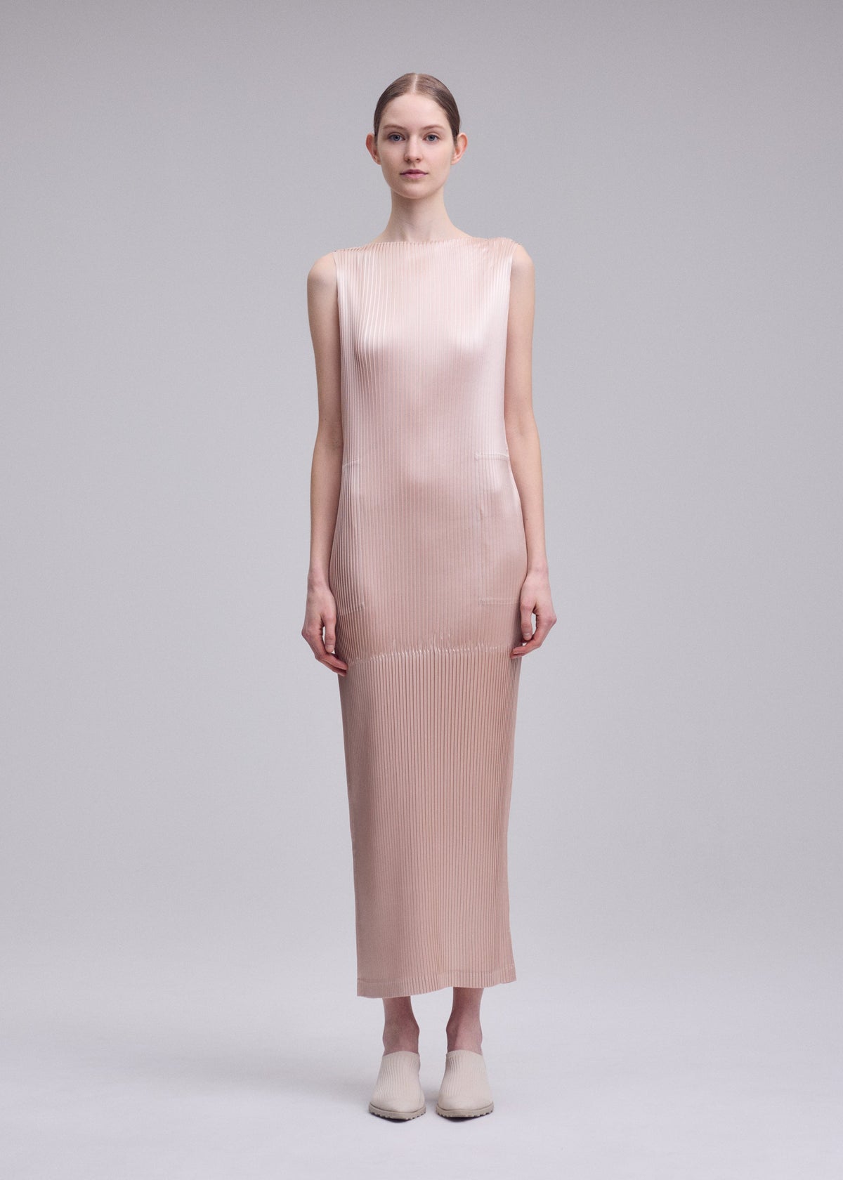 A model wears the ISSEY MIYAKE GLOSSED PANELS PLEATS glossed-panels-pleats-dress-grey.