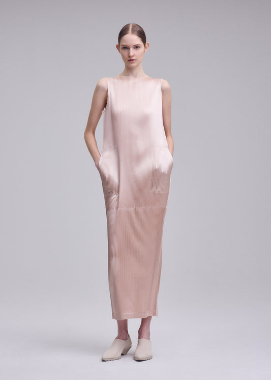A model wears the ISSEY MIYAKE GLOSSED PANELS PLEATS dress.