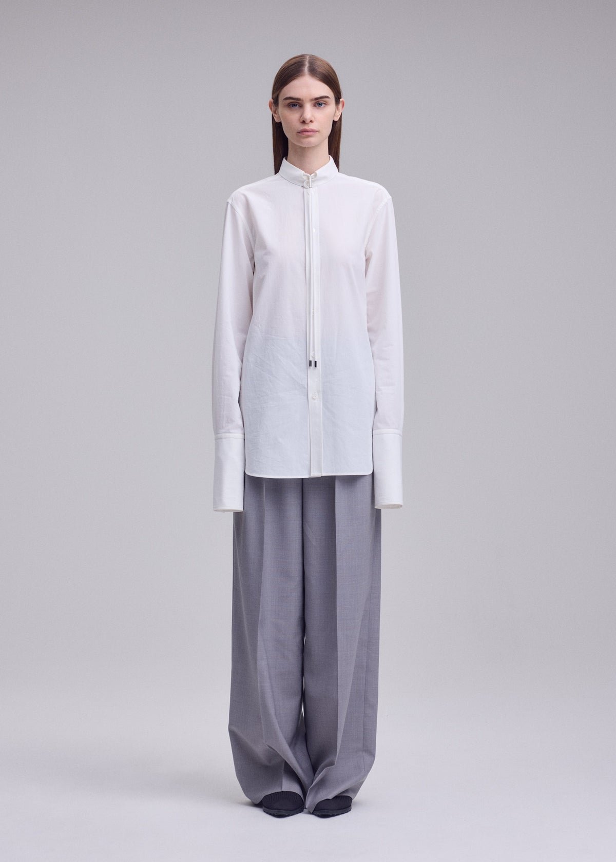 A model wears the ISSEY MIYAKE MONSIEUR SHIRT monsieur-shirt-shirt-white.