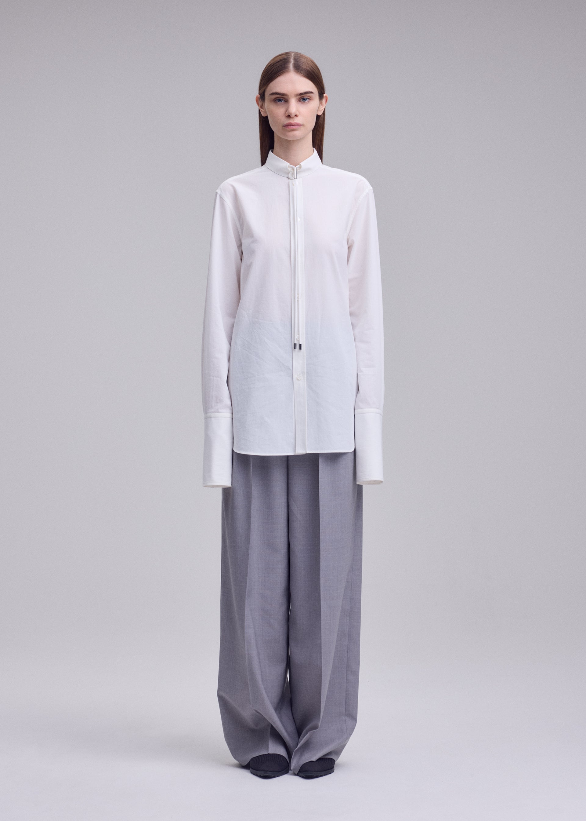 A model wears the ISSEY MIYAKE MONSIEUR SHIRT monsieur-shirt-shirt-black.