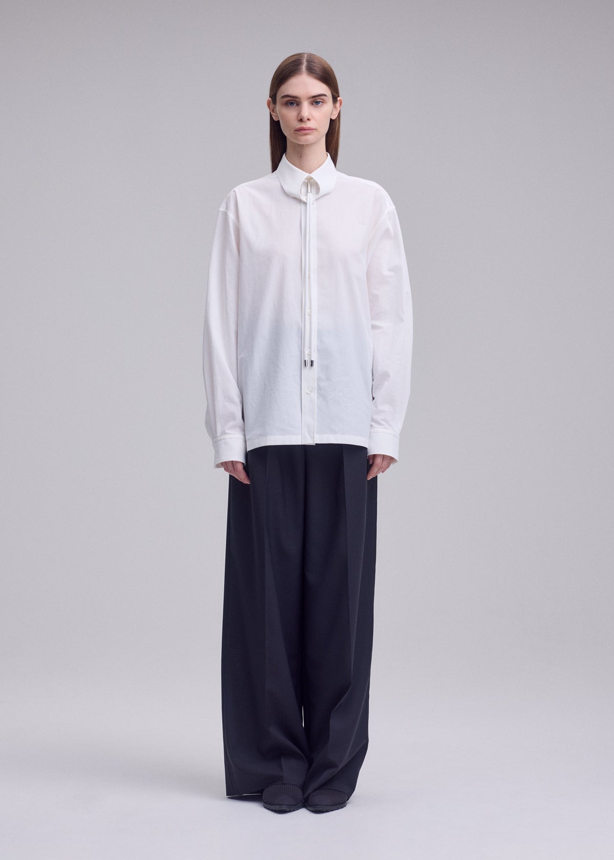 A model wears the ISSEY MIYAKE MONSIEUR SHIRT monsieur-shirt-shirt-black-1.