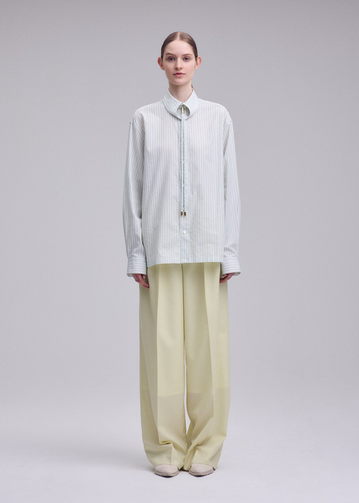 A model wears the ISSEY MIYAKE MONSIEUR SHIRT(DOBBY STRIPE) monsieur-shirt-dobby-stripe-shirt-blue-hued-1.