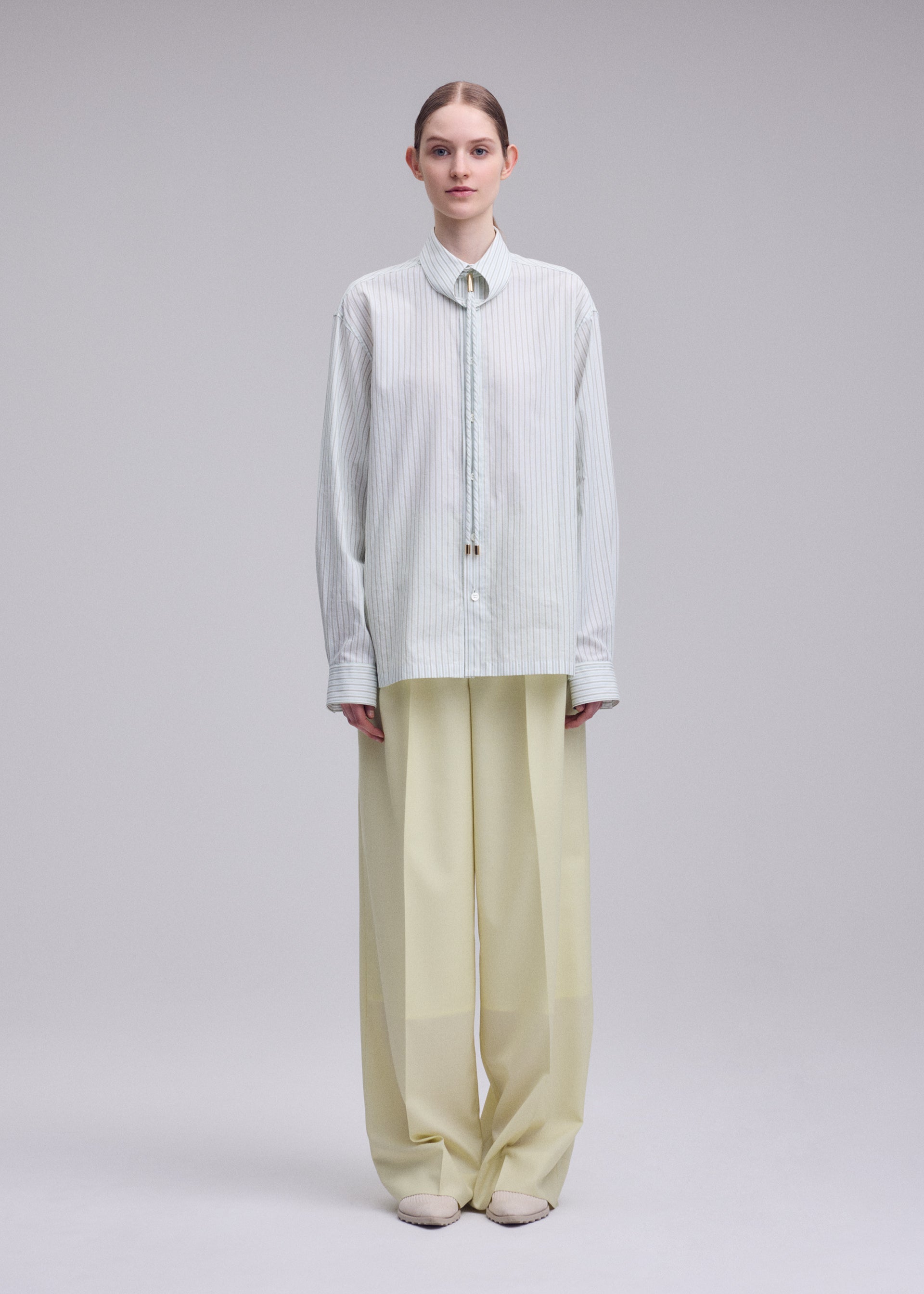 A model wears the ISSEY MIYAKE MONSIEUR SHIRT(DOBBY STRIPE) monsieur-shirt-dobby-stripe-shirt-blue-hued-1.