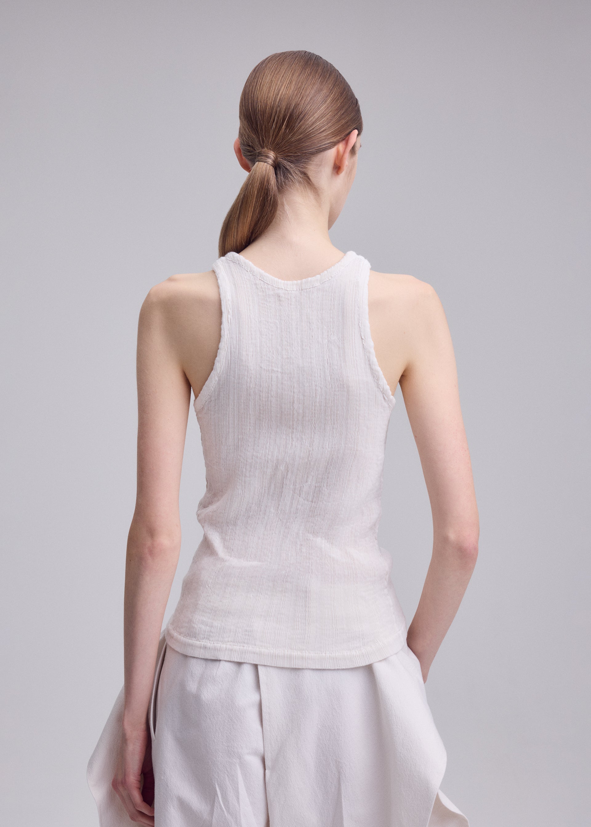 A model wears the ISSEY MIYAKE RILL rill-shirt-off-white.