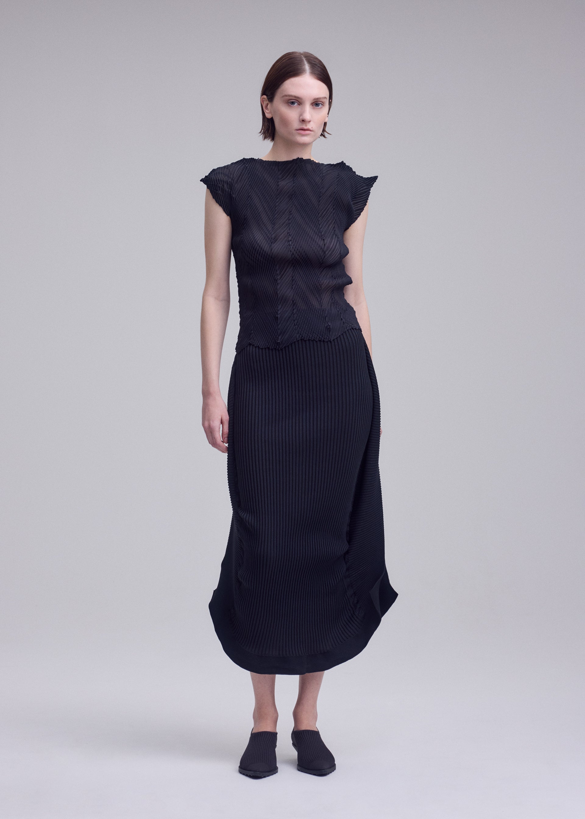 A model wears the ISSEY MIYAKE ZIGZAG PLEATS zigzag-pleats-shirt-black.