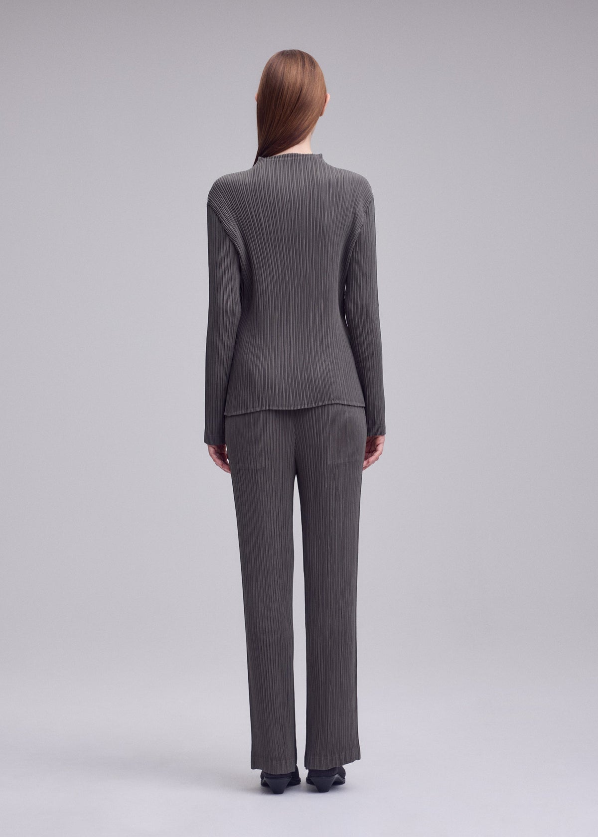A model wears the ISSEY MIYAKE HATCHING PLEATS shirt.