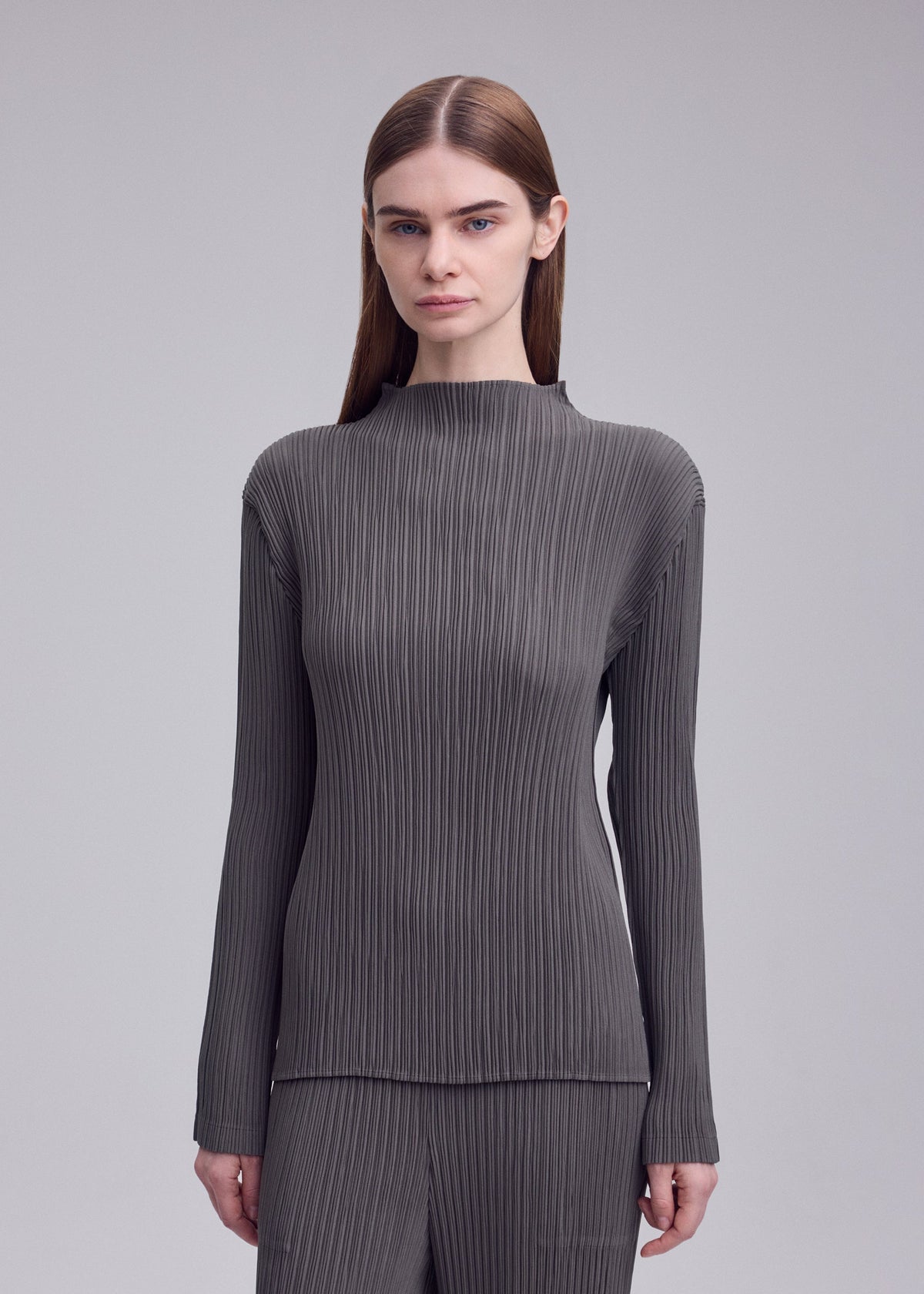A model wears the ISSEY MIYAKE HATCHING PLEATS shirt.