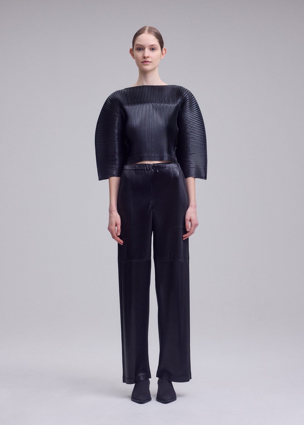 A model wears the ISSEY MIYAKE GLOSSED PANELS PLEATS glossed-panels-pleats-shirt-grey-1.