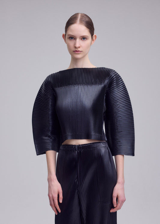 A model wears the ISSEY MIYAKE GLOSSED PANELS PLEATS shirt.