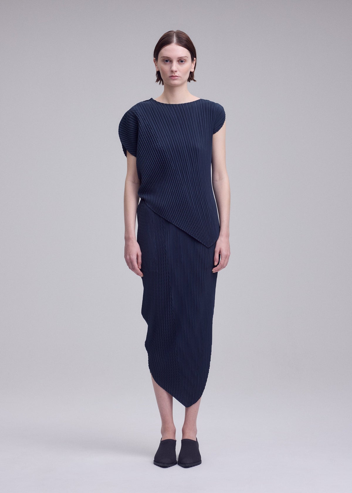 A model wears the ISSEY MIYAKE LEAF PLEATS leaf-pleats-shirt-off-white.