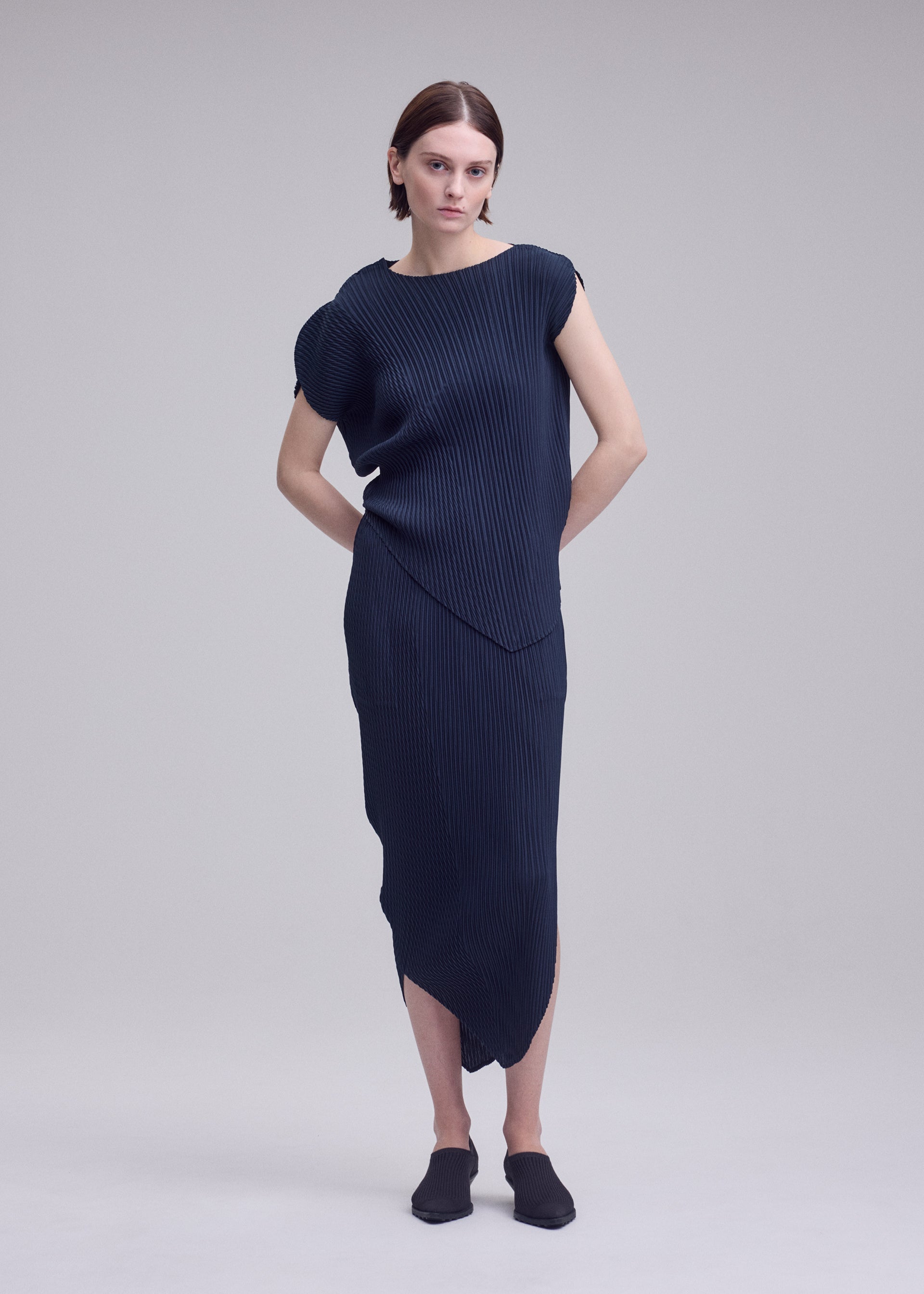 A model wears the ISSEY MIYAKE LEAF PLEATS leaf-pleats-shirt-off-white.