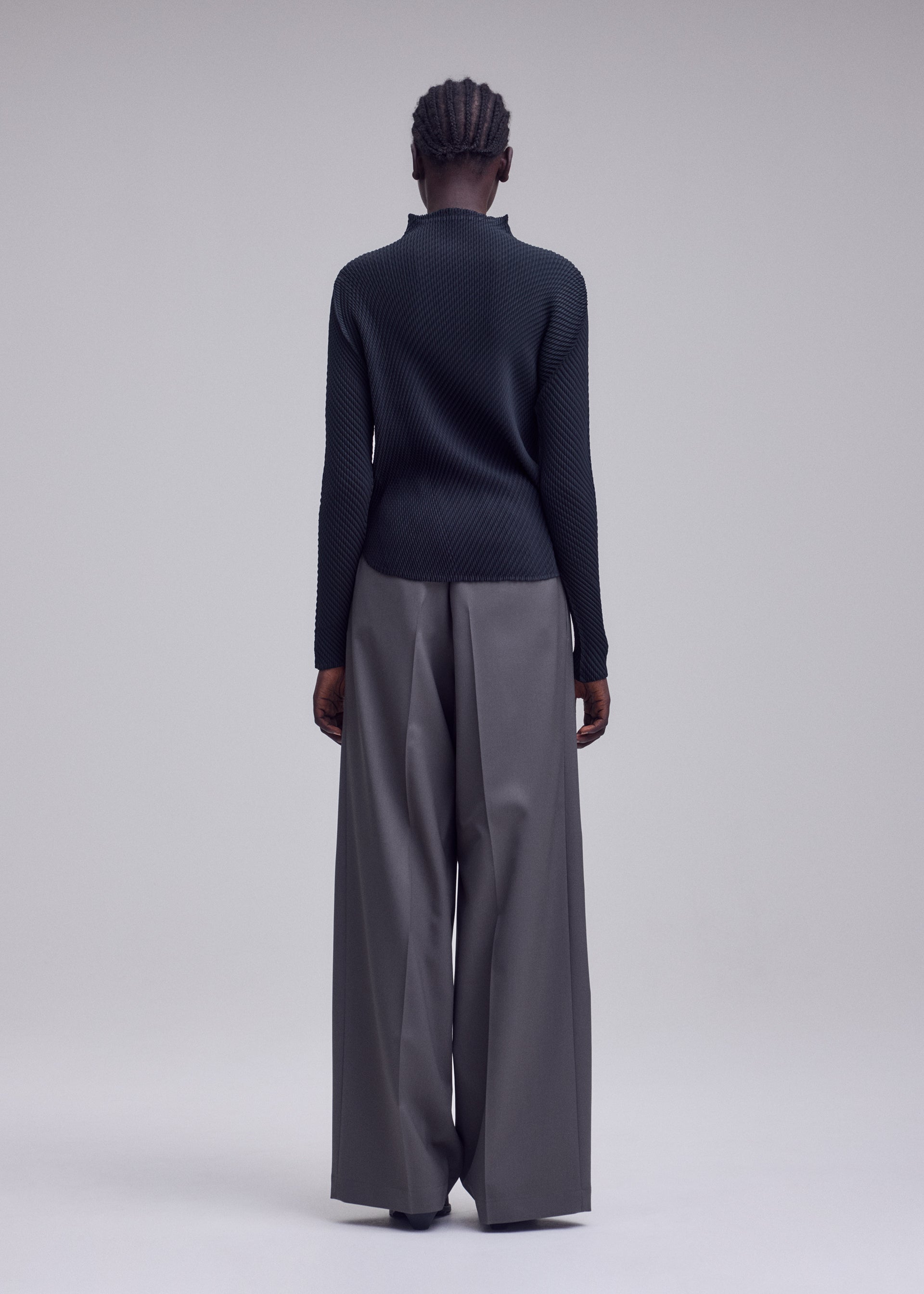 A model wears the ISSEY MIYAKE MISTY PLEATS shirt.