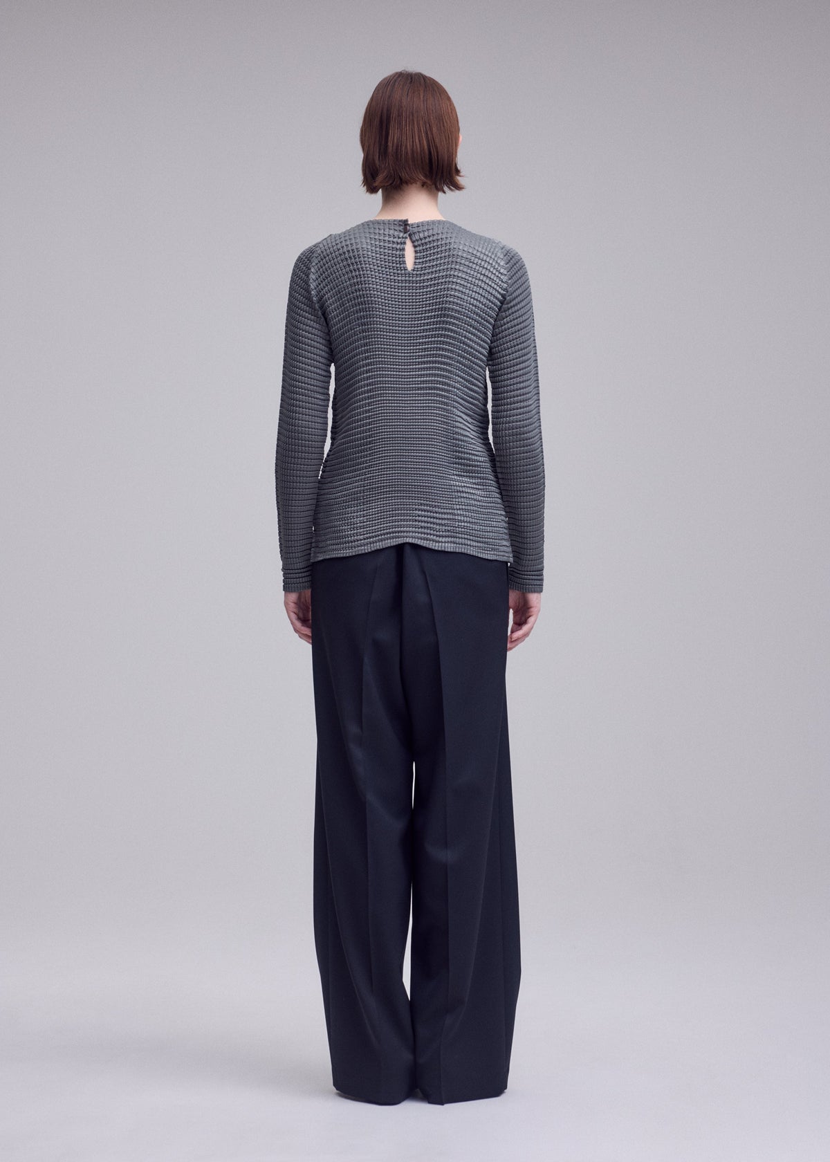 A model wears the ISSEY MIYAKE SUEDE LIKE PLEATS shirt.