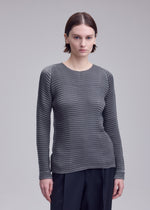 A model wears the ISSEY MIYAKE SUEDE LIKE PLEATS shirt.