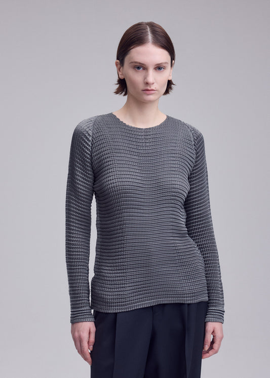 A model wears the ISSEY MIYAKE SUEDE LIKE PLEATS shirt.