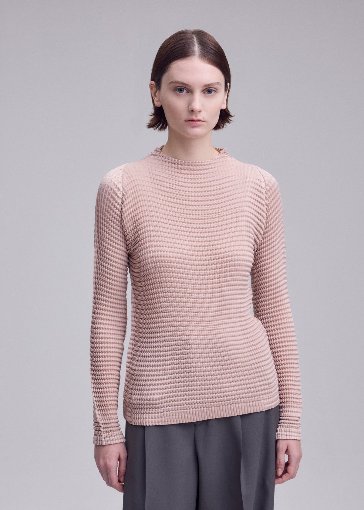 A model wears the ISSEY MIYAKE SUEDE LIKE PLEATS shirt.