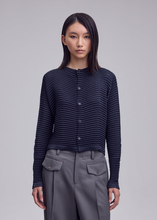 A model wears the ISSEY MIYAKE SUEDE LIKE PLEATS shirt.