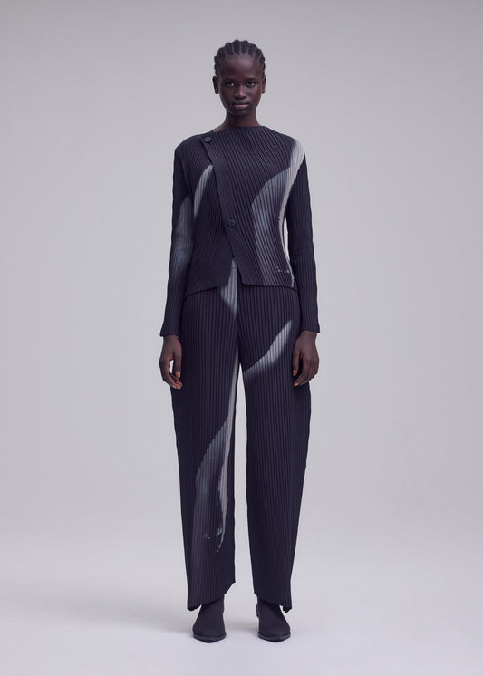 A model wears the ISSEY MIYAKE HANDS OF LOVER PLEATS cardigan.
