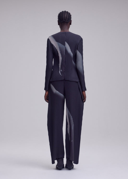 A model wears the ISSEY MIYAKE HANDS OF LOVER PLEATS cardigan.