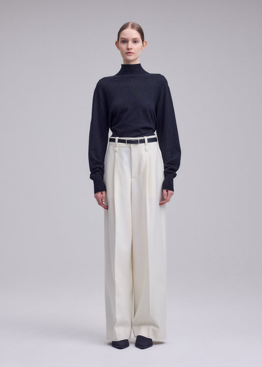 A model wears the ISSEY MIYAKE SHELL trousers.