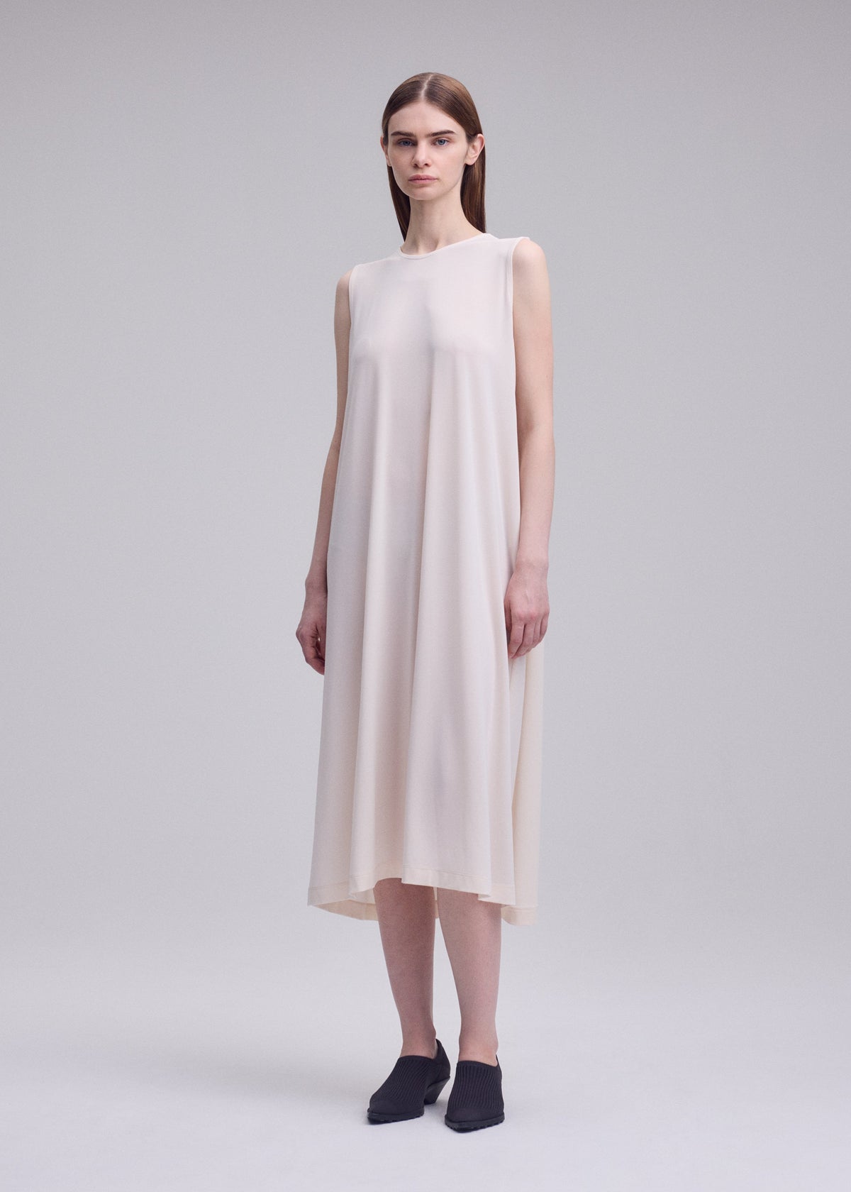 A model wears the ISSEY MIYAKE DRAPE JERSEY-68 drape-jersey-68-dress-off-white.