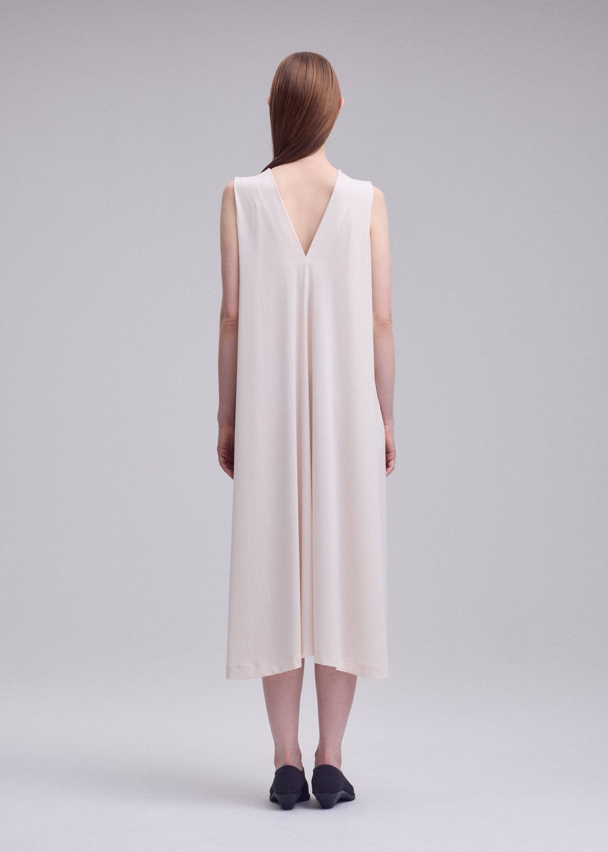 A model wears the ISSEY MIYAKE DRAPE JERSEY-68 drape-jersey-68-dress-dark-navy-2.