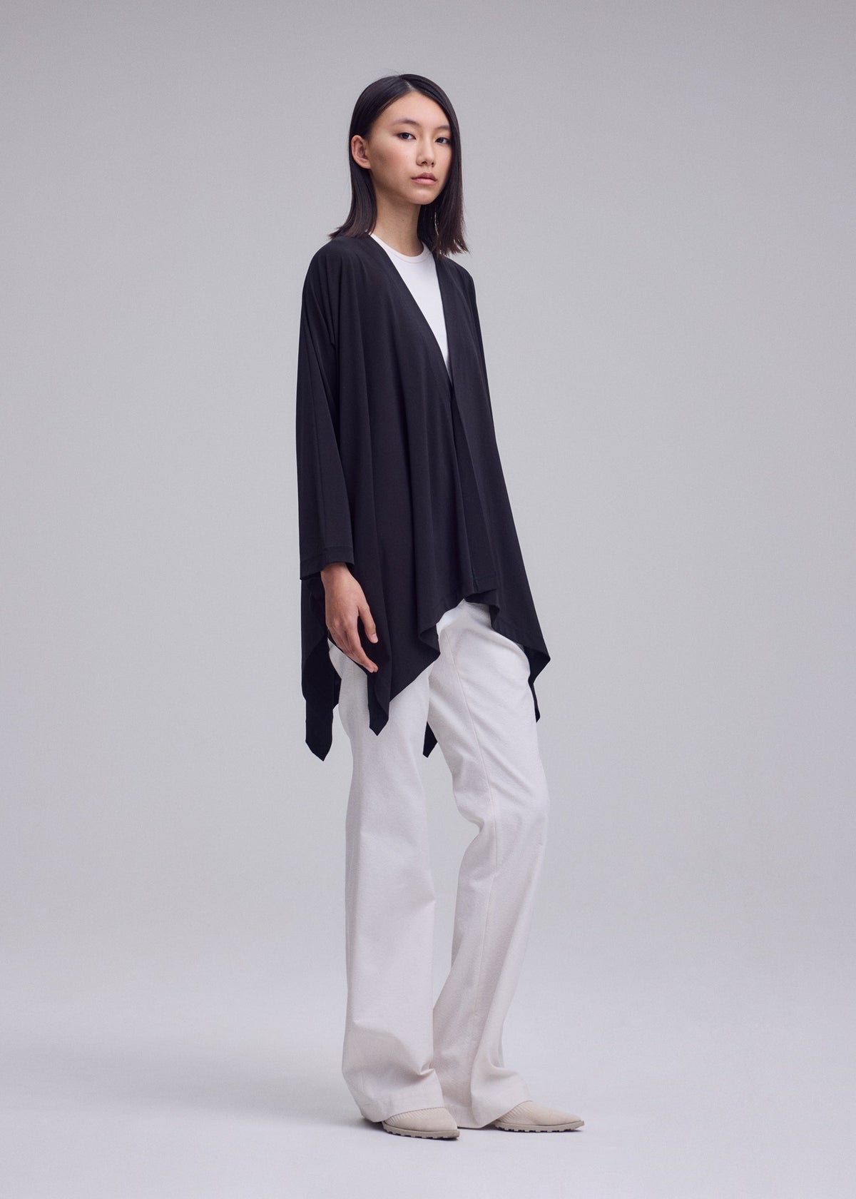 A model wears the ISSEY MIYAKE DRAPE JERSEY-68 drape-jersey-68-cardigan-dark-navy-2.