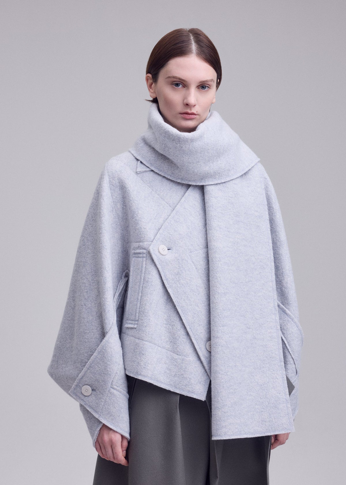 A model wears the ISSEY MIYAKE WOOLEN GRANITE coat.