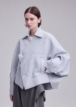 A model wears the ISSEY MIYAKE WOOLEN GRANITE coat.
