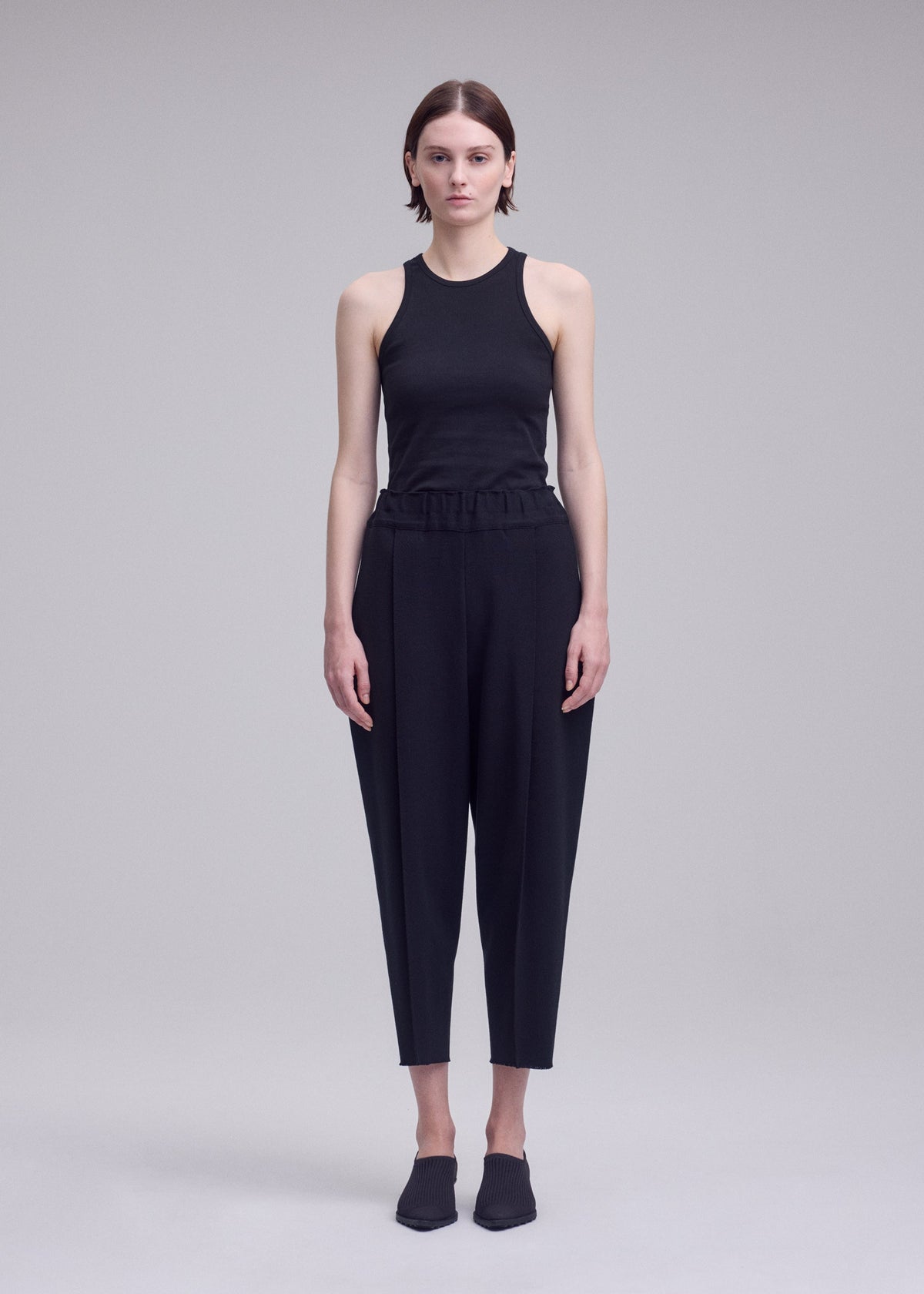 A model wears the ISSEY MIYAKE CAMPAGNE campagne-trousers-black-16.