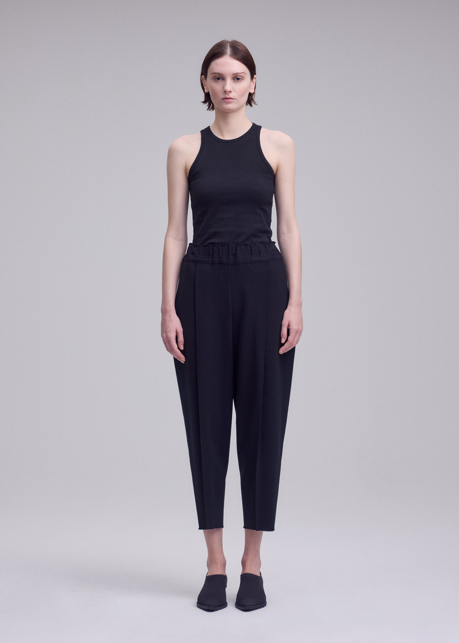 A model wears the ISSEY MIYAKE CAMPAGNE campagne-trousers-dark-navy.