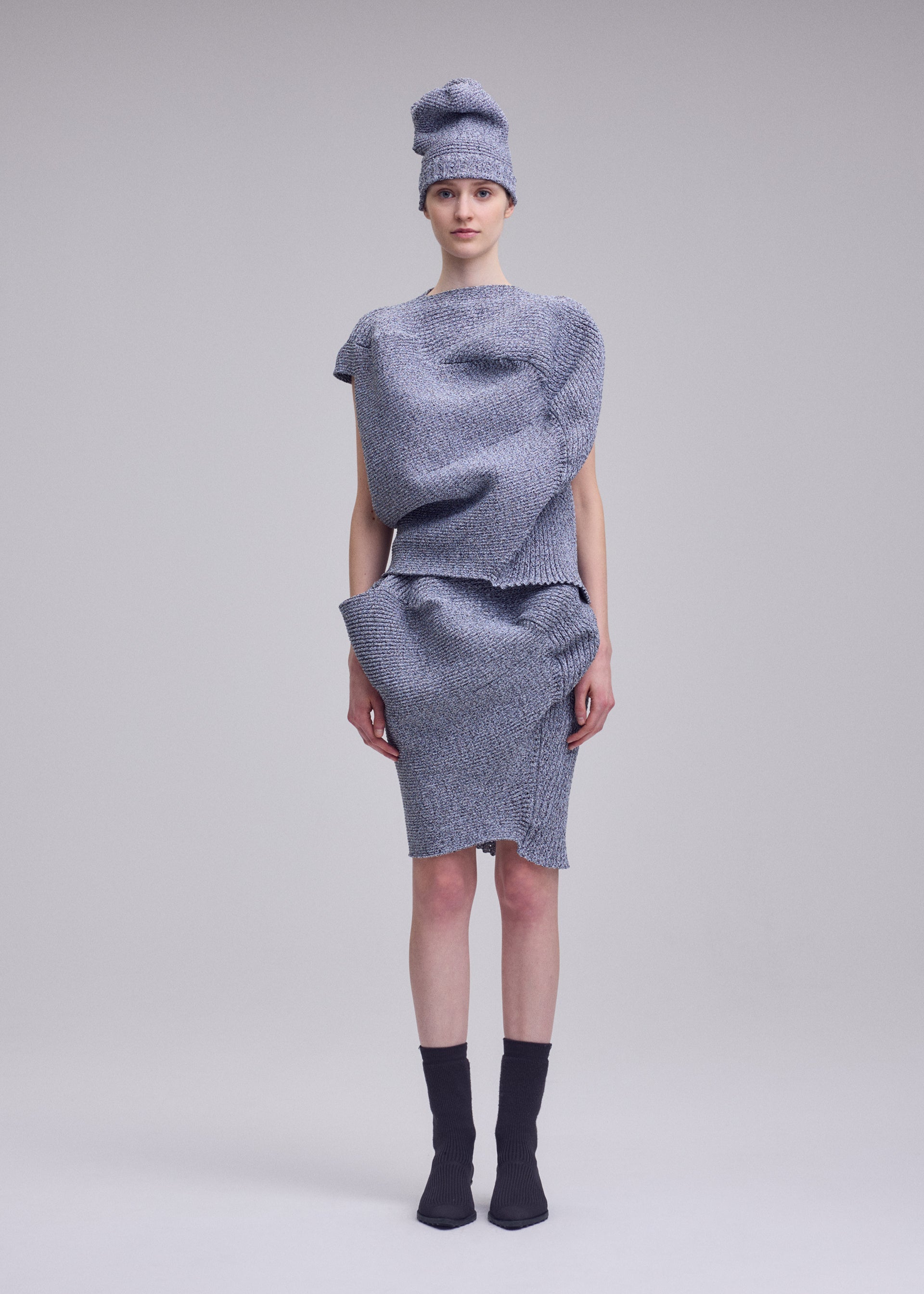 A model wears the ISSEY MIYAKE FOUND STONE found-stone-skirt-grey-1.