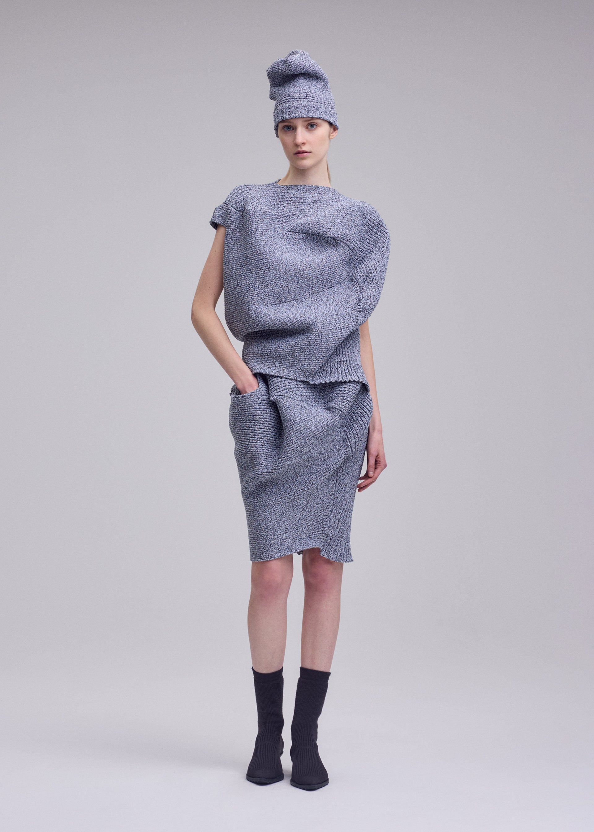 A model wears the ISSEY MIYAKE FOUND STONE found-stone-skirt-black-2.