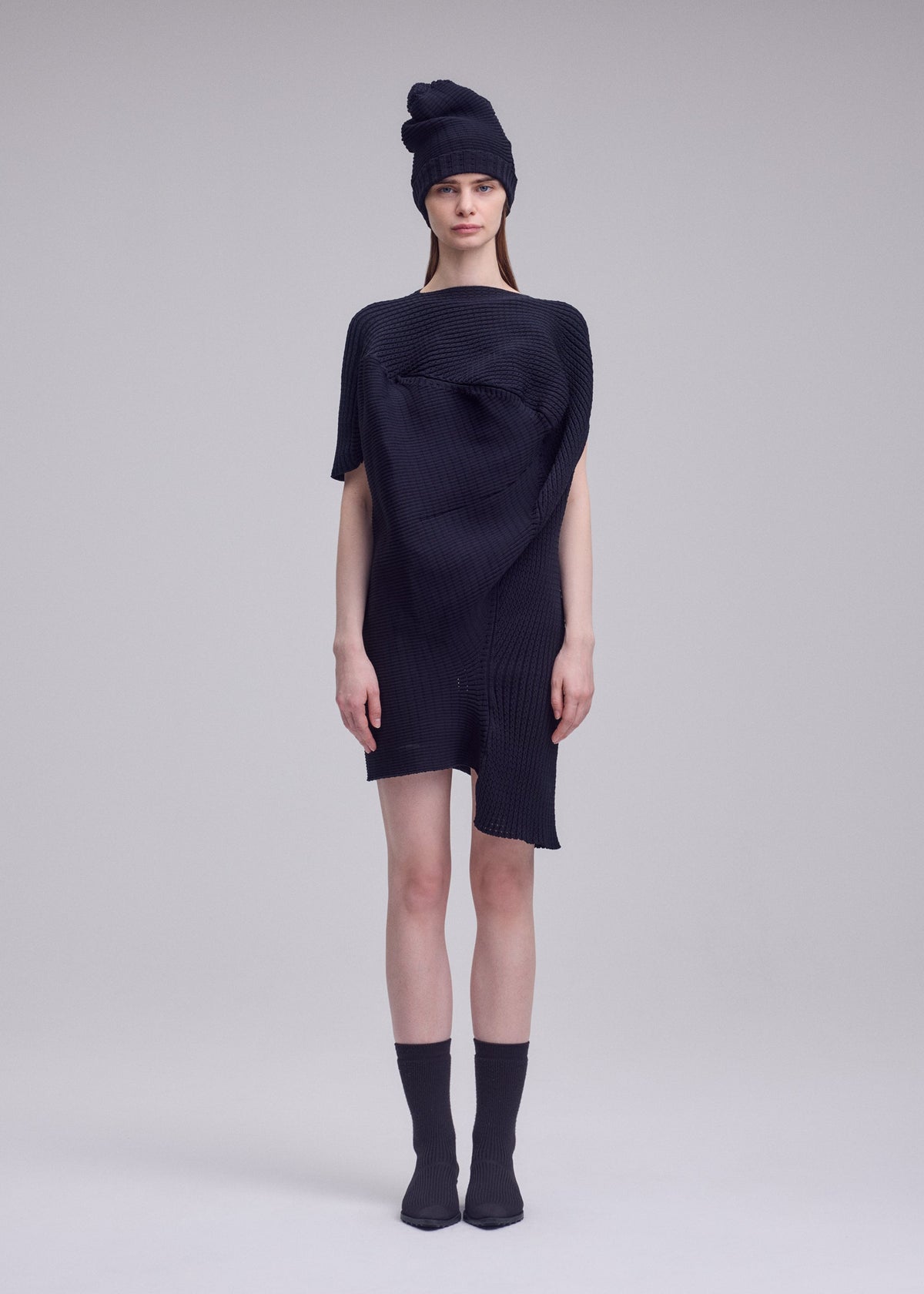 A model wears the ISSEY MIYAKE FOUND STONE found-stone-dress-off-white.